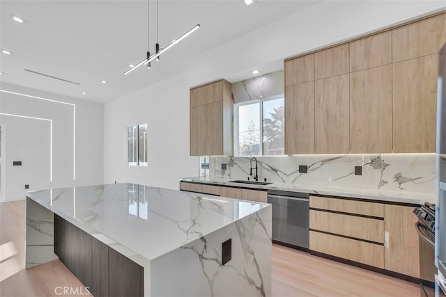 kitchen with a large island, sink, backsplash, stainless steel appliances, and light stone countertops