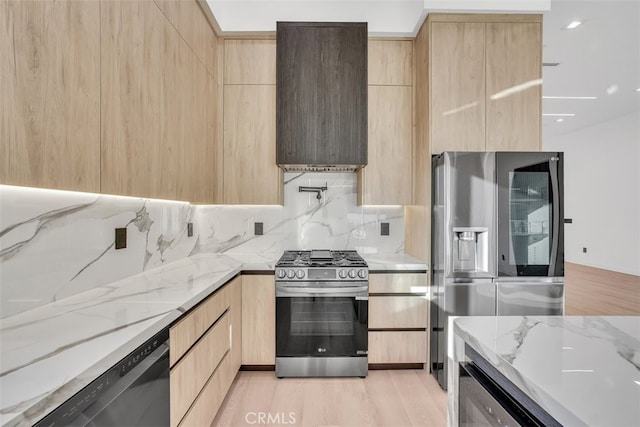 kitchen featuring light brown cabinetry, light stone countertops, and stainless steel appliances