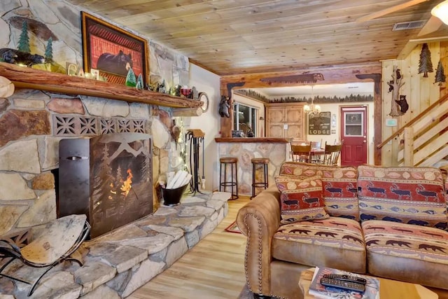 living room with a fireplace, light wood-type flooring, and wood ceiling