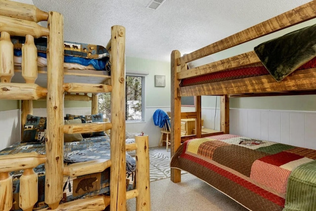 carpeted bedroom with a textured ceiling and wooden walls