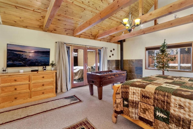 rec room featuring beamed ceiling, a notable chandelier, a wood stove, and light carpet