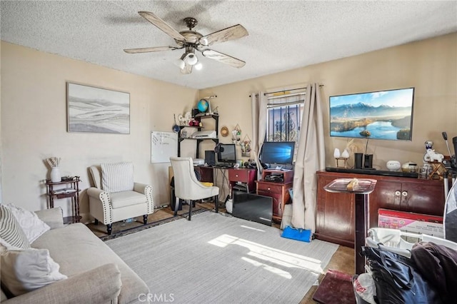 living room featuring ceiling fan and a textured ceiling