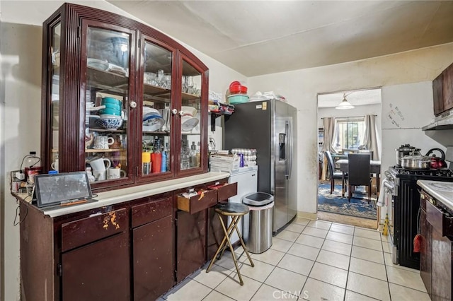 kitchen featuring light tile patterned floors, range with gas cooktop, and stainless steel fridge with ice dispenser