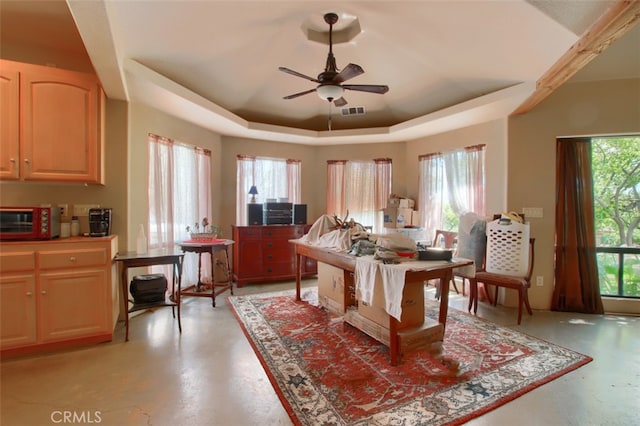 dining space with a raised ceiling, plenty of natural light, and ceiling fan