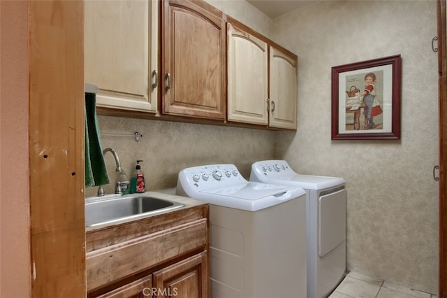 clothes washing area featuring cabinets, light tile patterned floors, washer and clothes dryer, and sink