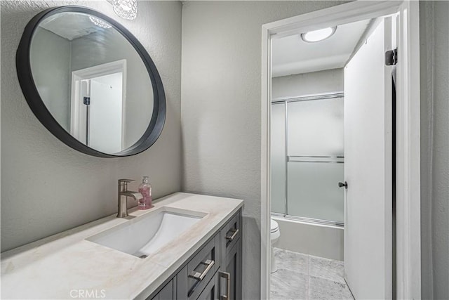 full bathroom featuring shower / bath combination with glass door, vanity, and toilet