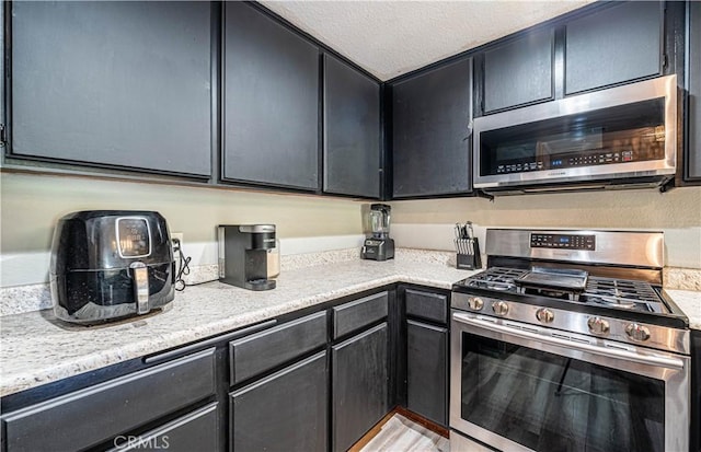 kitchen with appliances with stainless steel finishes and a textured ceiling