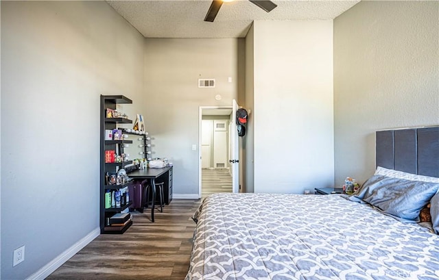 bedroom featuring ceiling fan, dark hardwood / wood-style floors, and a textured ceiling