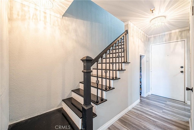 stairs featuring hardwood / wood-style flooring and an inviting chandelier