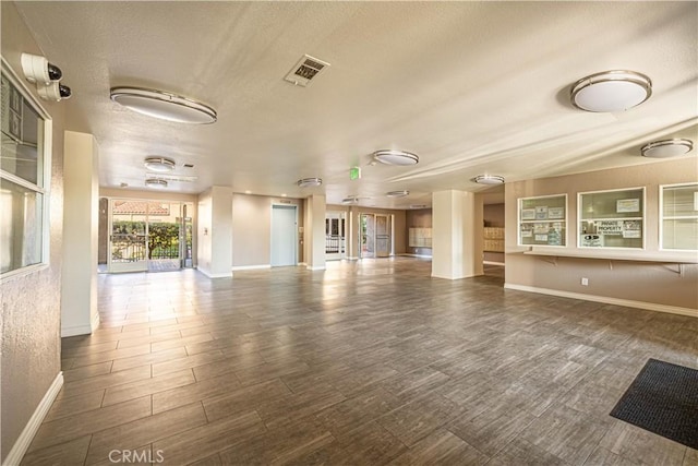 unfurnished living room featuring wood-type flooring and a textured ceiling