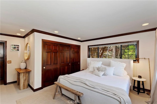 carpeted bedroom with a closet and crown molding