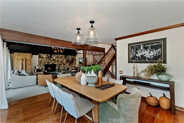27538 W Shore Rd, Lake Arrowhead, CA 92352 - dining room featuring wood finished floors, stairway, a stone fireplace, and crown molding