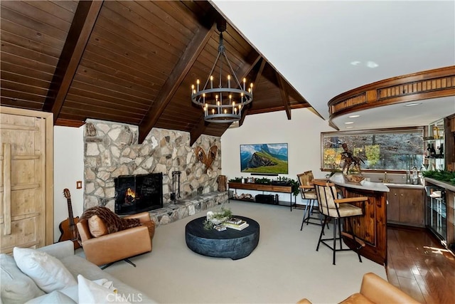 living room with wooden ceiling, vaulted ceiling with beams, a stone fireplace, and an inviting chandelier