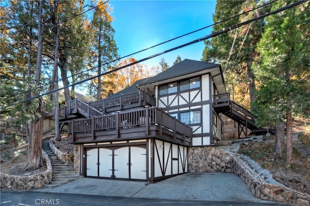 rear view of property with a garage and a wooden deck