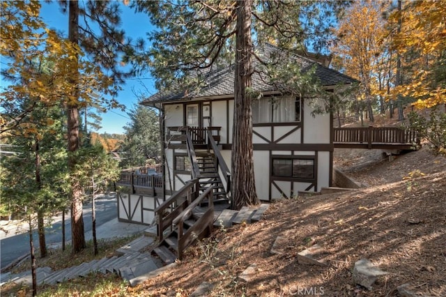 27538 W Shore Rd, Lake Arrowhead, CA 92352 - view of front of property with stucco siding, stairway, a deck, and roof with shingles