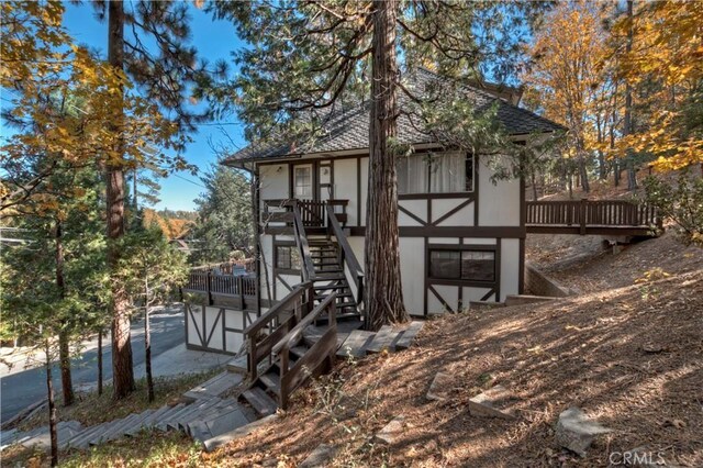 27538 W Shore Rd, Lake Arrowhead, CA 92352 - view of front of home with stucco siding, stairway, a wooden deck, and a shingled roof