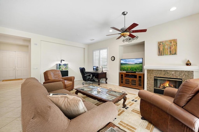 tiled living room with a fireplace and ceiling fan