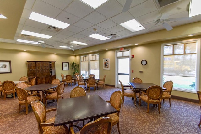 carpeted dining space featuring a paneled ceiling and ceiling fan