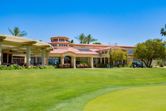 view of front facade with ceiling fan, a pergola, and a front yard