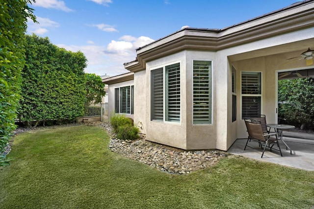 back of house with a lawn, ceiling fan, and a patio