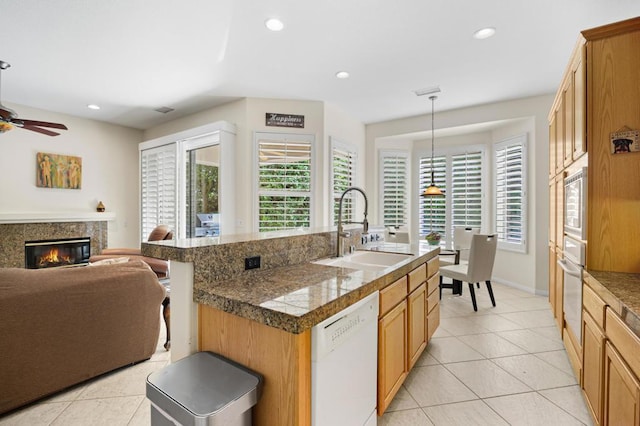 kitchen featuring decorative light fixtures, white dishwasher, a wealth of natural light, and sink