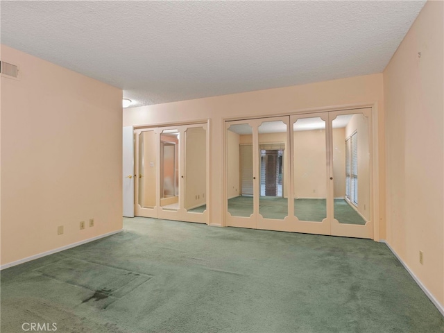 unfurnished room with carpet flooring and a textured ceiling