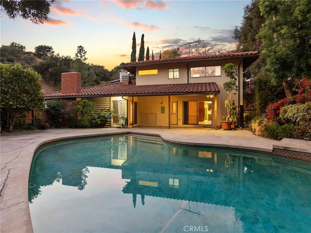 pool at dusk with a patio