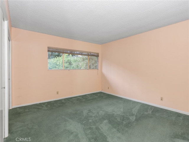 carpeted empty room with a textured ceiling