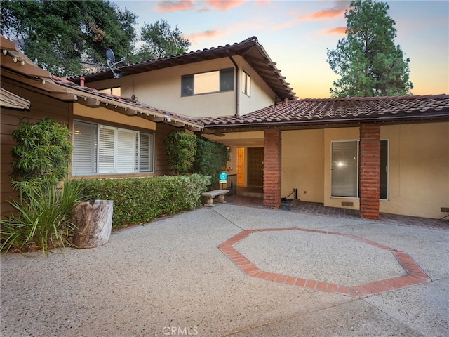 exterior entry at dusk with a patio