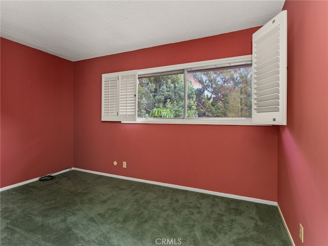 unfurnished room with a textured ceiling and dark colored carpet