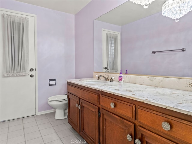 bathroom featuring tile patterned floors, vanity, toilet, and an inviting chandelier