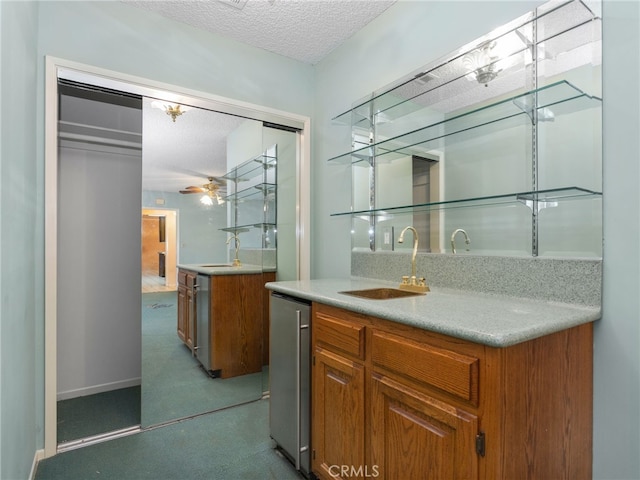 bar with ceiling fan, sink, and a textured ceiling