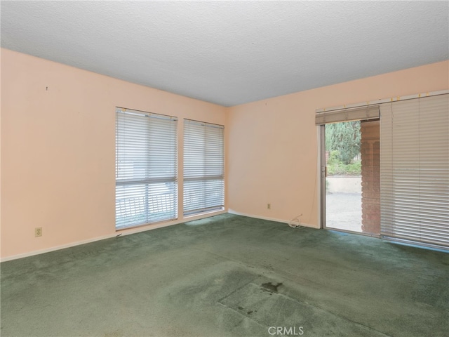 carpeted spare room with a textured ceiling