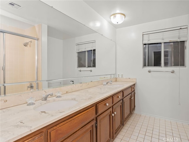 bathroom with tile patterned flooring, vanity, and an enclosed shower