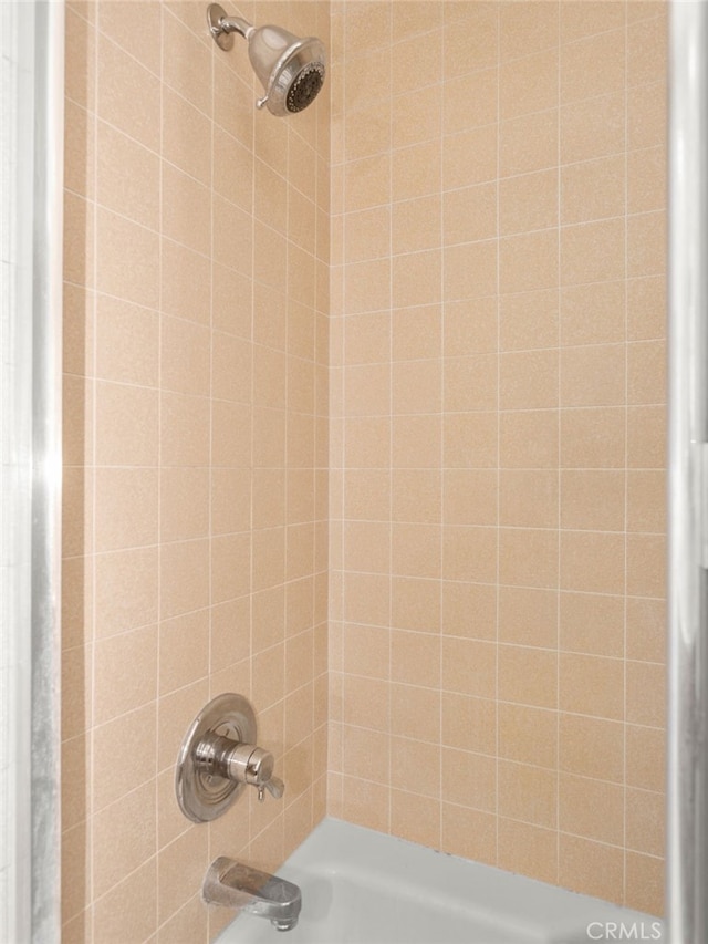 interior details with tiled shower / bath combo