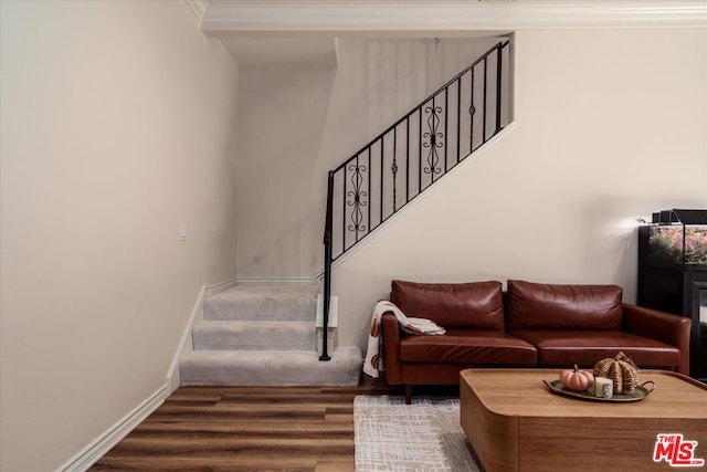 stairway with hardwood / wood-style flooring and ornamental molding