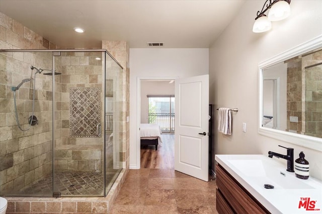 bathroom featuring wood-type flooring, vanity, and a shower with shower door