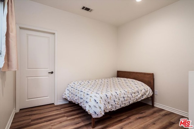 bedroom with dark wood-type flooring