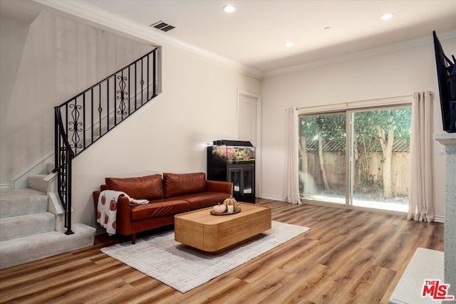 living room with hardwood / wood-style flooring and crown molding