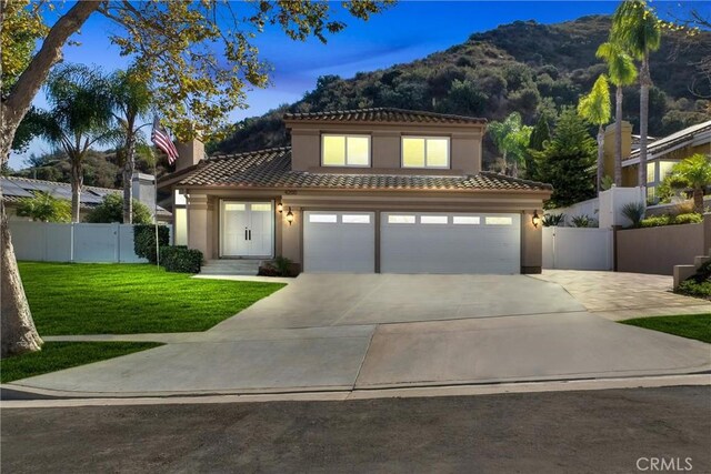 mediterranean / spanish house featuring a yard and a garage