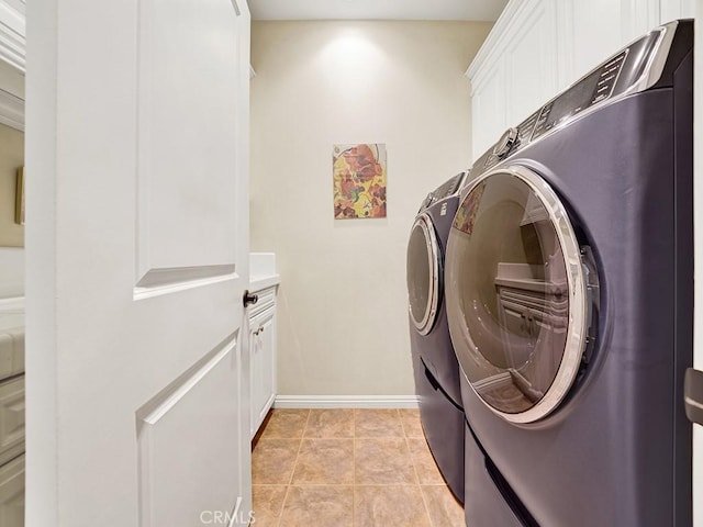 laundry area featuring cabinets, washer and dryer, and light tile patterned floors