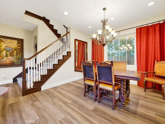 dining space with an inviting chandelier and light hardwood / wood-style floors