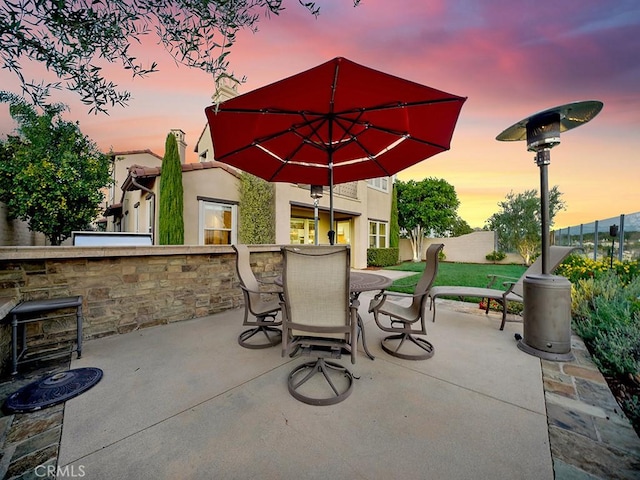 patio terrace at dusk featuring an outdoor bar