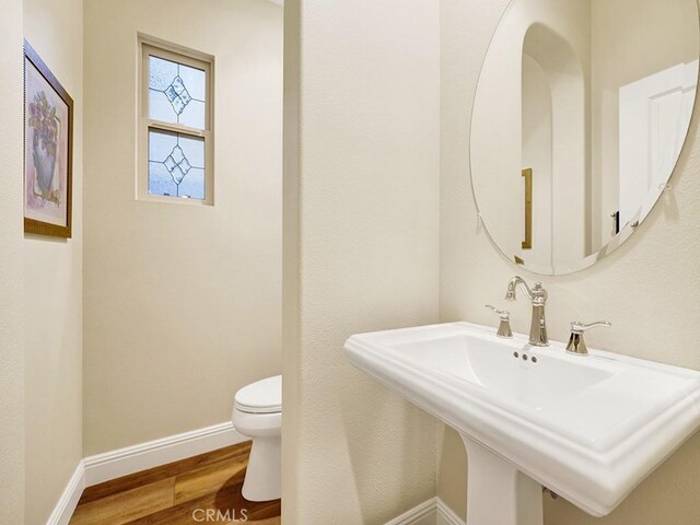 bathroom with sink, wood-type flooring, and toilet