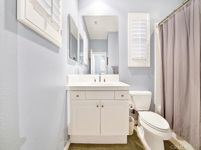 full bathroom featuring vanity, shower / bath combination with curtain, and toilet