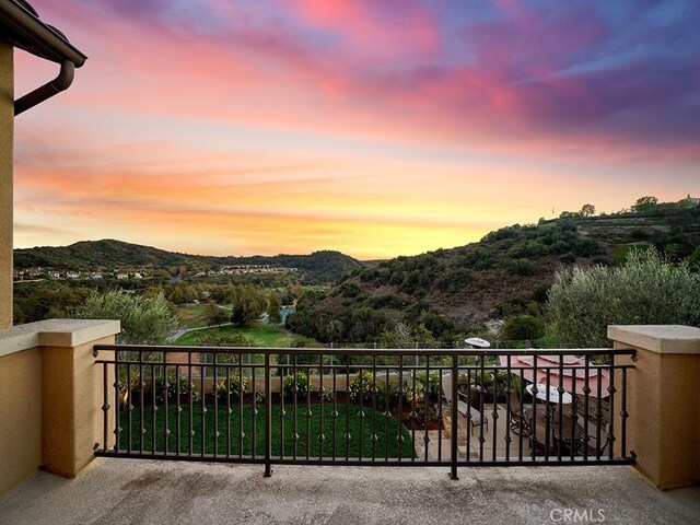 balcony at dusk featuring a mountain view