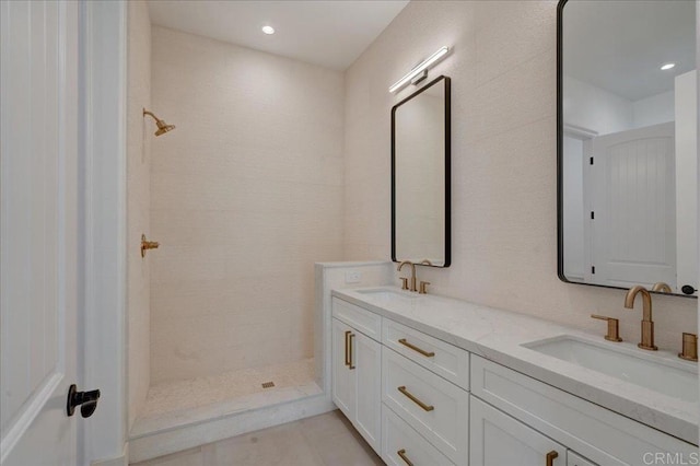 bathroom featuring a tile shower and vanity