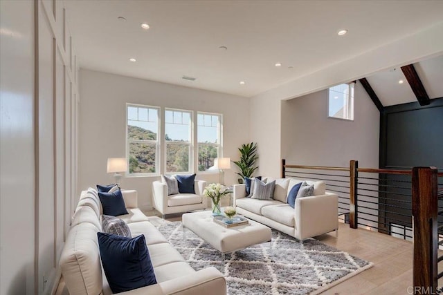 living room with lofted ceiling with beams and light hardwood / wood-style floors