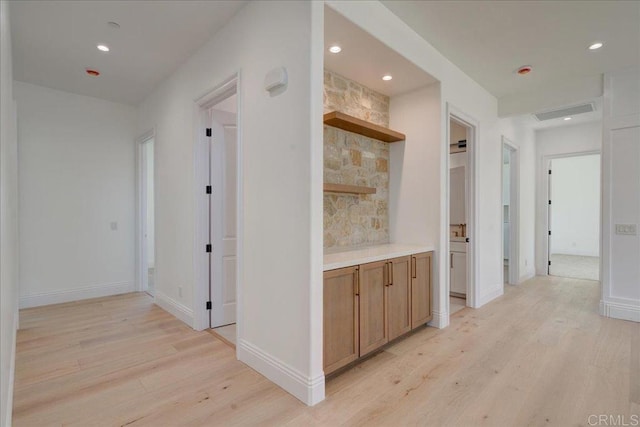 corridor with light hardwood / wood-style floors