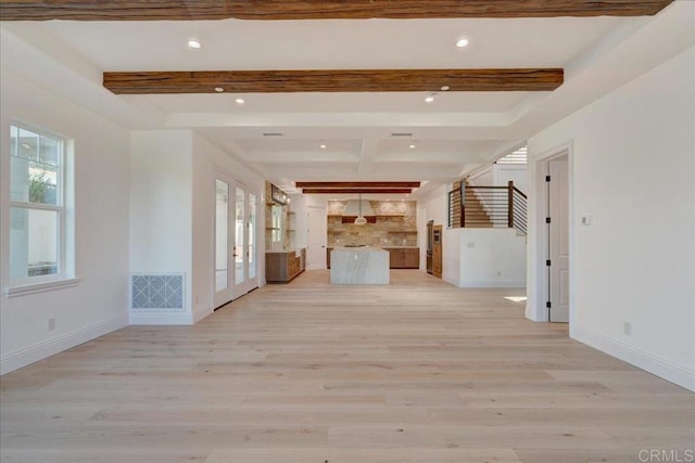 unfurnished living room with beam ceiling and light hardwood / wood-style flooring